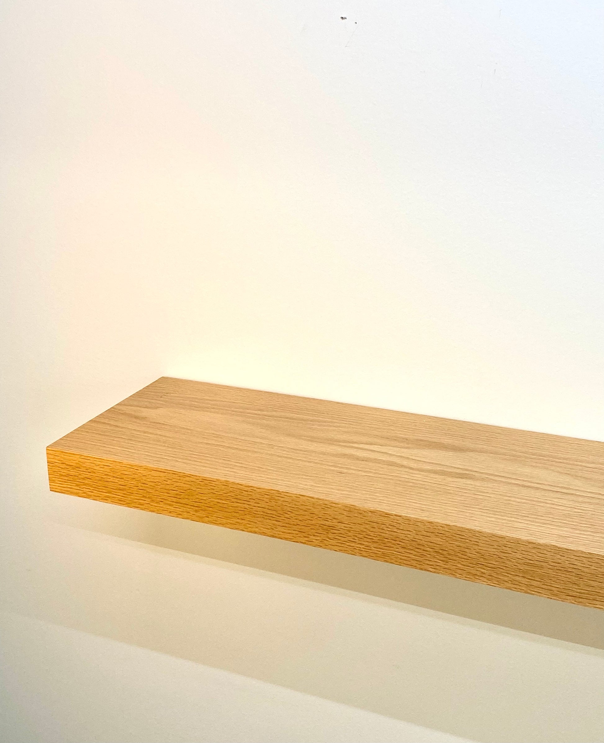 simple floating oak shelf with bracket on wall